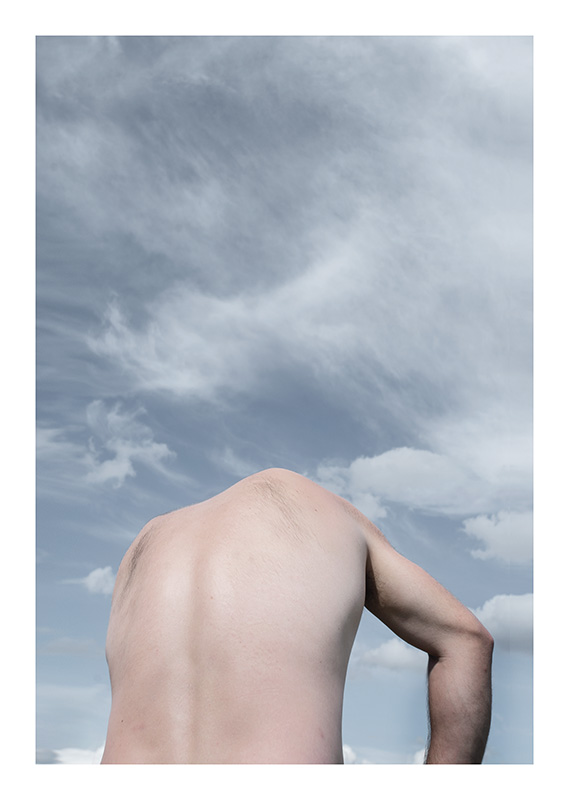 Nackter Rücken eines Mannes ohne Kopf vor Himmel mit Wolken